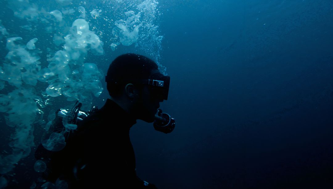 Diver Explores Deep Ocean in Wetsuit and Mask with Bubbles