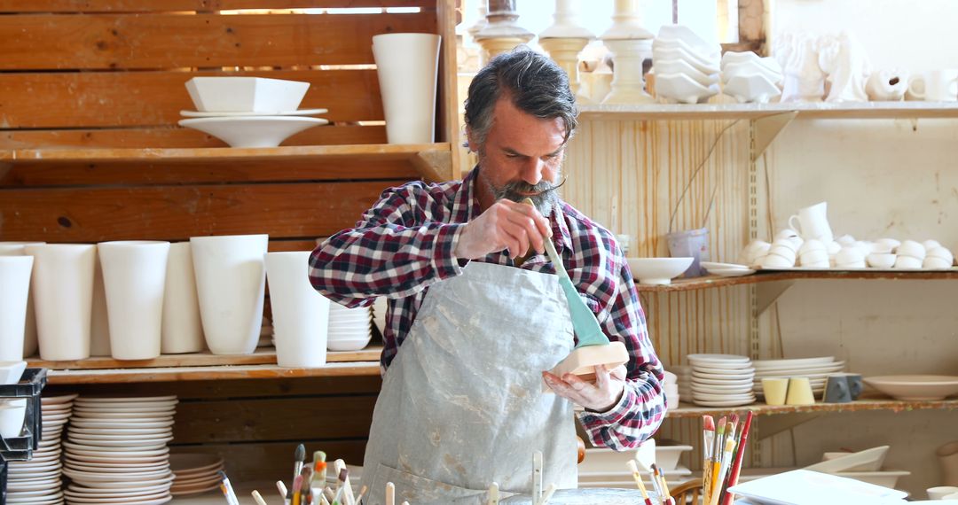 Senior Male Artisan Glazing Pottery in Studio - Free Images, Stock Photos and Pictures on Pikwizard.com