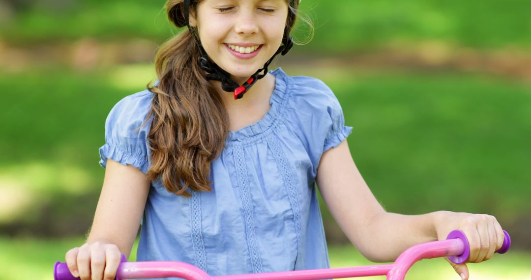 Young Girl Riding Bicycle with Smiling Face and Safety Helmet - Free Images, Stock Photos and Pictures on Pikwizard.com