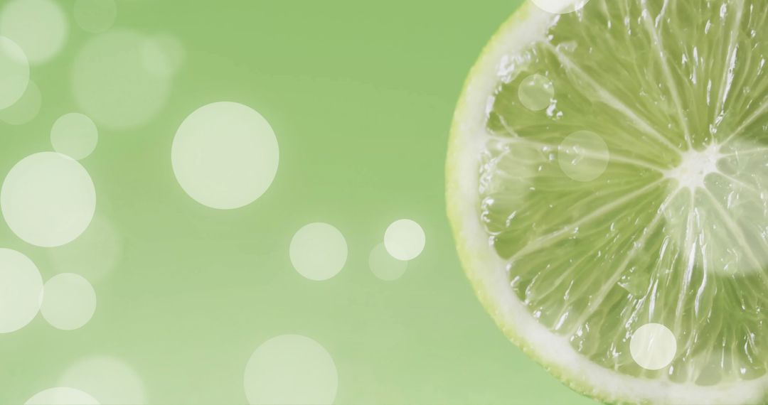 Sliced Lime with Glowing White Bokeh Overlay on Green Background