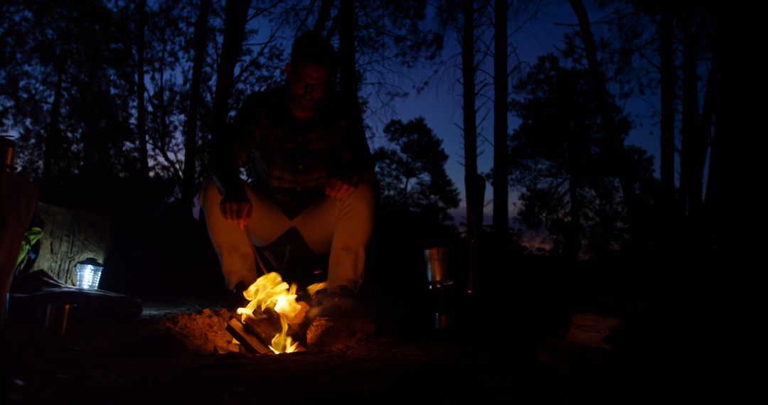 Man Camping with Bonfire in Forest during Dusk - Free Images, Stock Photos and Pictures on Pikwizard.com