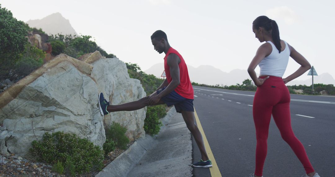 Couple Stretching During Outdoor Workout on Mountain Road with Scenic Background - Free Images, Stock Photos and Pictures on Pikwizard.com