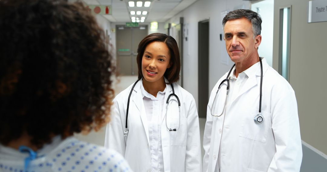 Doctors Consulting Patient in Hospital Corridor - Free Images, Stock Photos and Pictures on Pikwizard.com