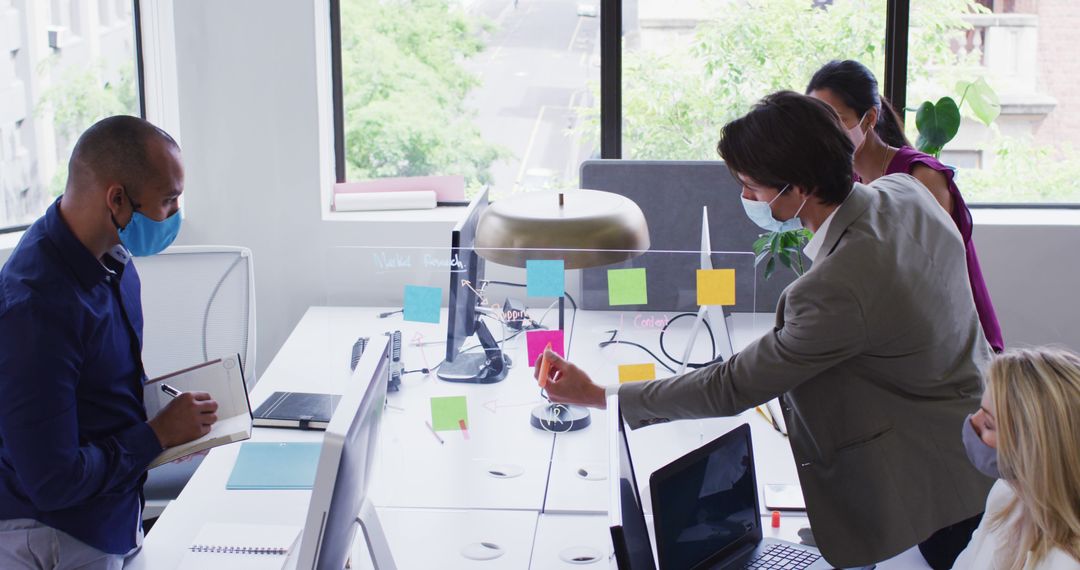 Diverse Colleagues Collaborating with Face Masks at Modern Office Desk