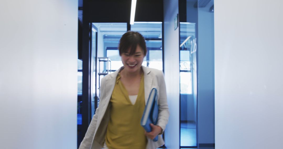 Smiling Businesswoman Walking Through Modern Office Corridor - Free Images, Stock Photos and Pictures on Pikwizard.com