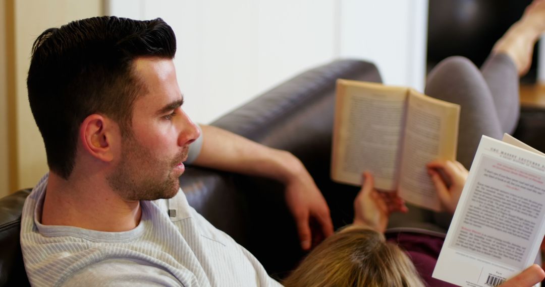 Couple Relaxing on Sofa Enjoying Books at Home