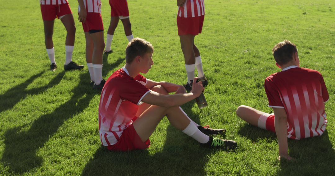 Soccer Team Taking a Break on Field - Free Images, Stock Photos and Pictures on Pikwizard.com