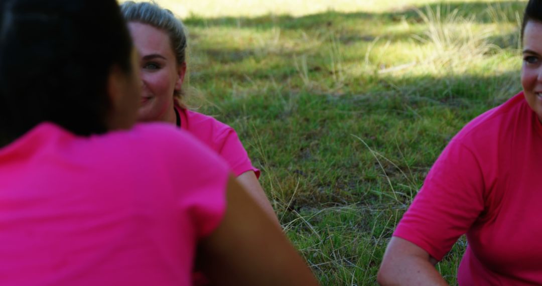 Women in Pink Shirts Enjoying Outdoor Conversation on Grass - Free Images, Stock Photos and Pictures on Pikwizard.com