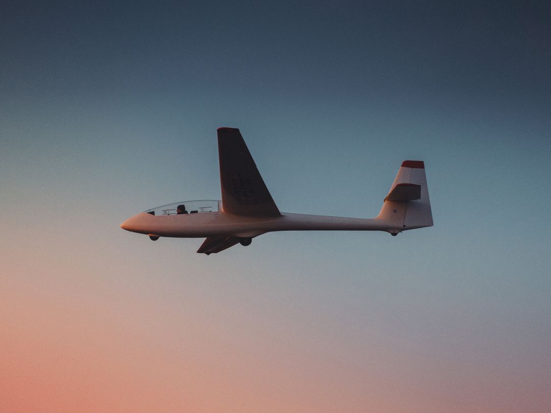 Glider Soaring Against a Colorful Sunset Sky