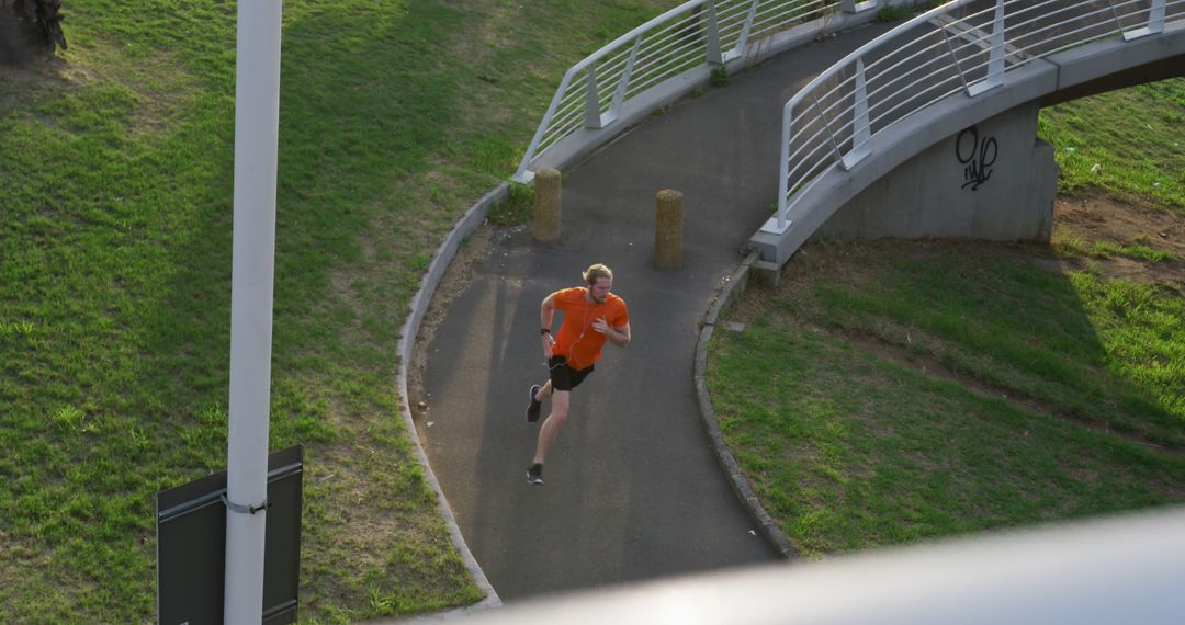 Man Running on Curved Bridge Path in Urban Park - Free Images, Stock Photos and Pictures on Pikwizard.com