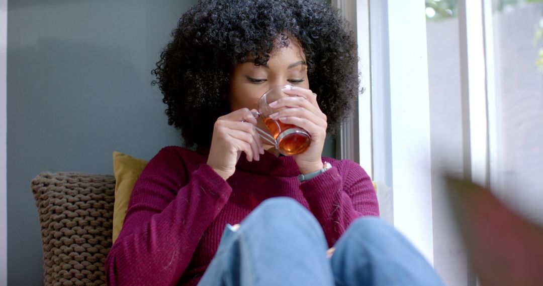 Woman Relaxing at Home Drinking Tea by the Window - Free Images, Stock Photos and Pictures on Pikwizard.com