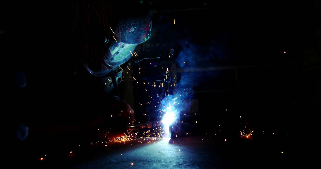 Welder Performing Industrial Metalwork in Low Light with Sparks - Free Images, Stock Photos and Pictures on Pikwizard.com