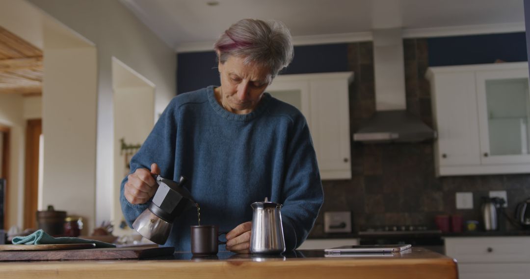 Senior Woman Preparing Coffee in Spacious Kitchen - Free Images, Stock Photos and Pictures on Pikwizard.com