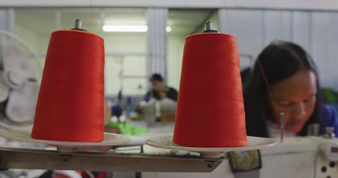 Two large spools of red thread in focus in a textile factory - Free Images, Stock Photos and Pictures on Pikwizard.com