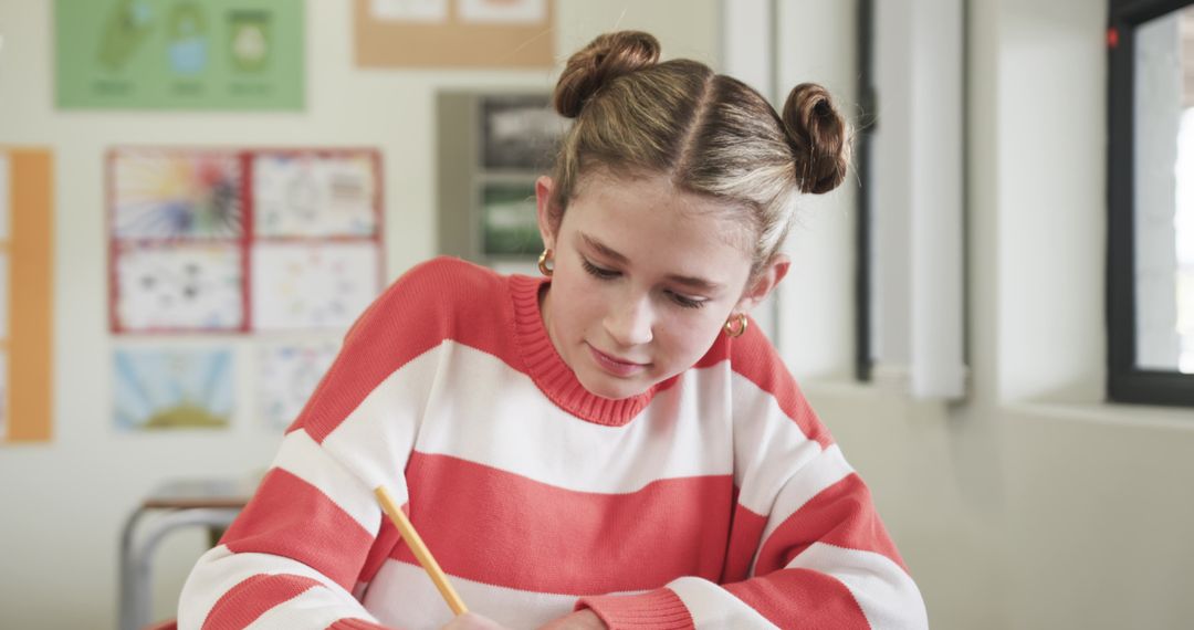 Girl Focused on Schoolwork in Classroom by Window