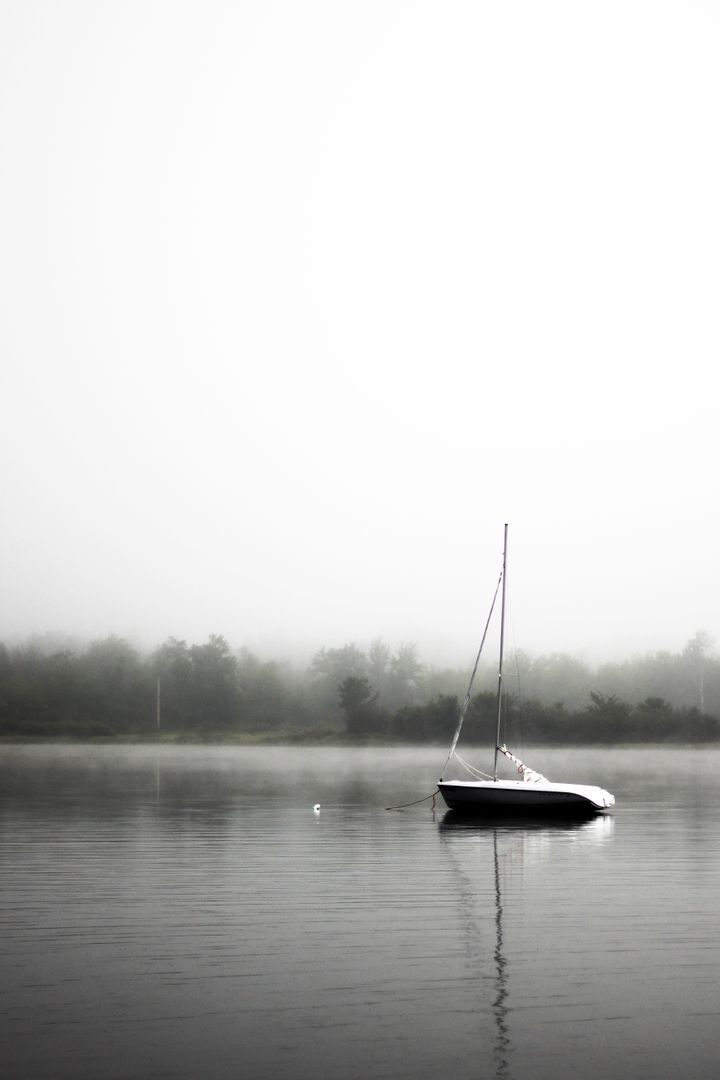 Lonely Sailboat on Serene Misty Lake - Free Images, Stock Photos and Pictures on Pikwizard.com