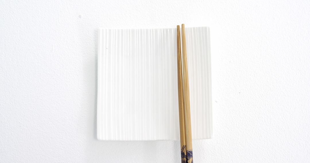 Square Ceramic Plate with Wooden Chopsticks Against White Background - Free Images, Stock Photos and Pictures on Pikwizard.com