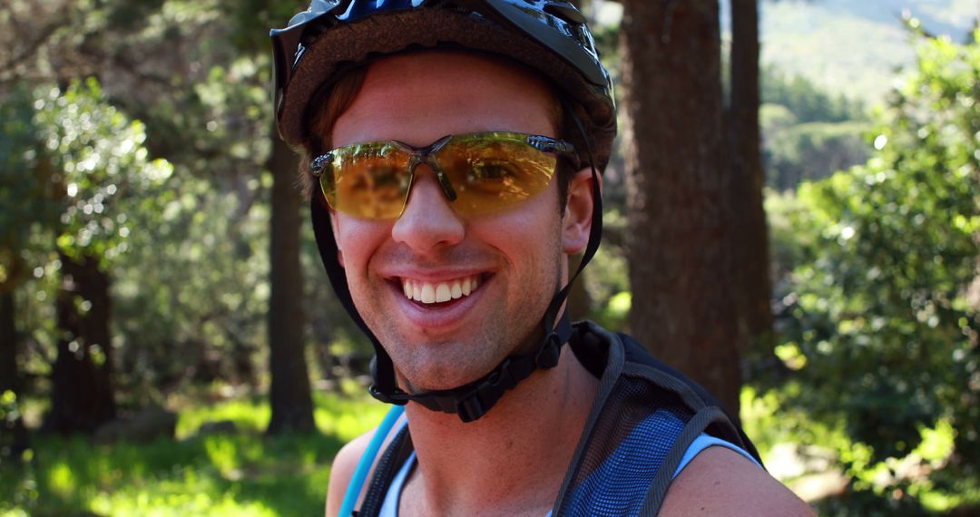 Young Man Wearing Helmet and Sunglasses Smiling in Forest - Free Images, Stock Photos and Pictures on Pikwizard.com