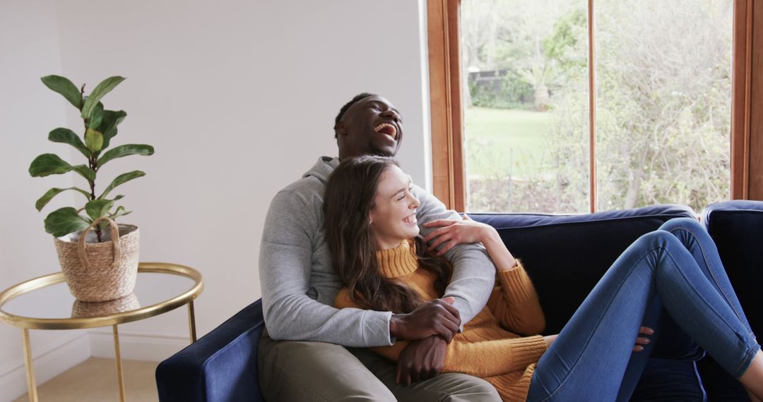 Relaxed Diverse Couple Laughing on Couch at Home
