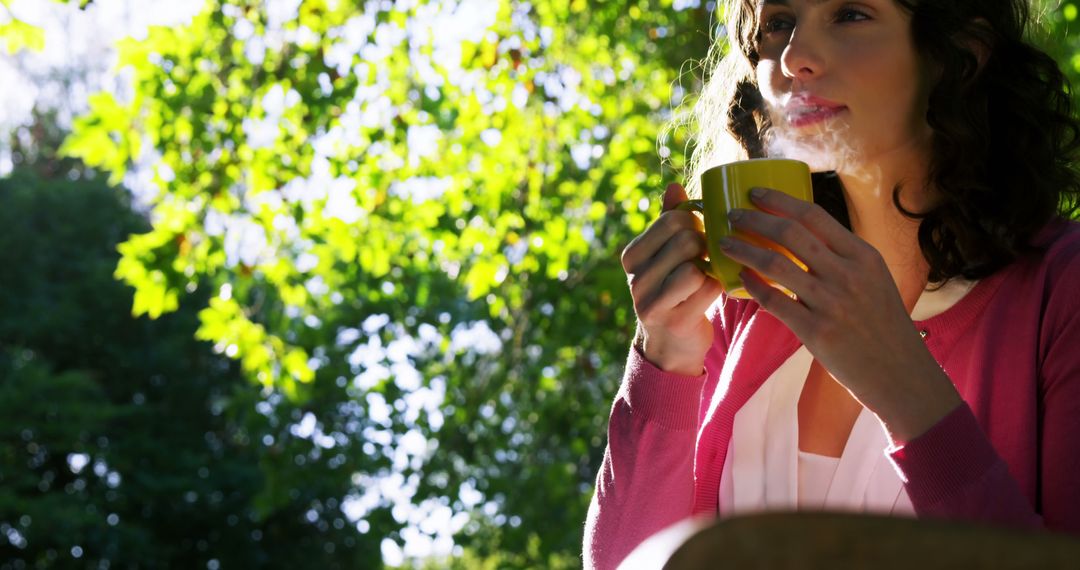 Woman Enjoying Hot Beverage on Sunny Morning Outdoors - Free Images, Stock Photos and Pictures on Pikwizard.com