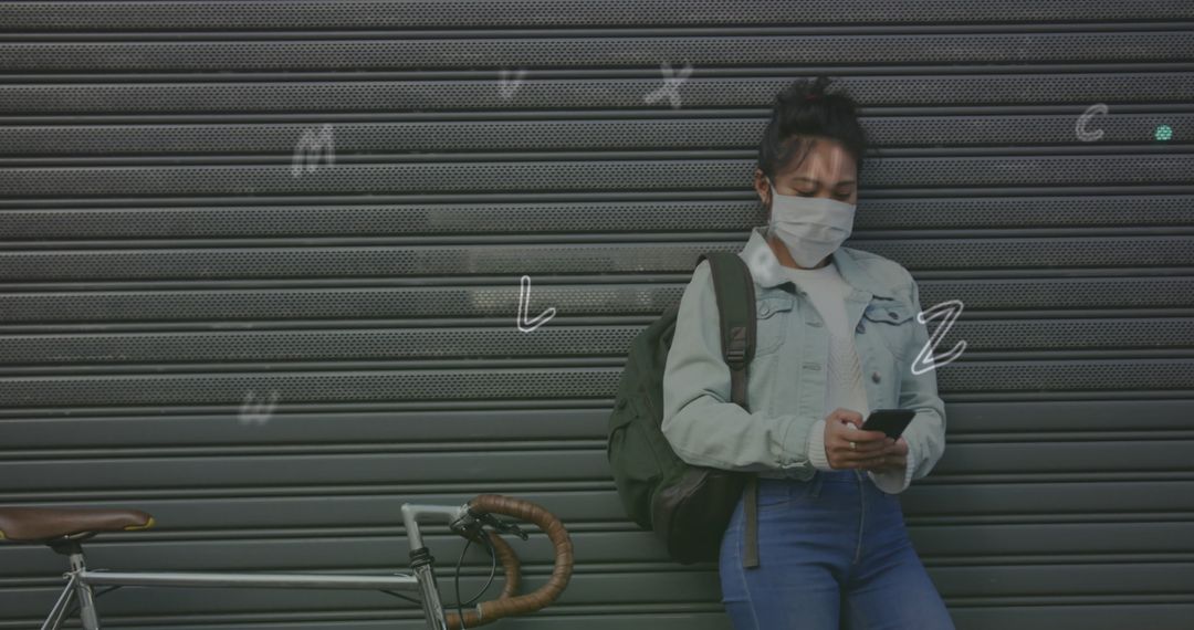 Woman Wearing Face Mask Using Smartphone with Overlaying Alphabet Graphics