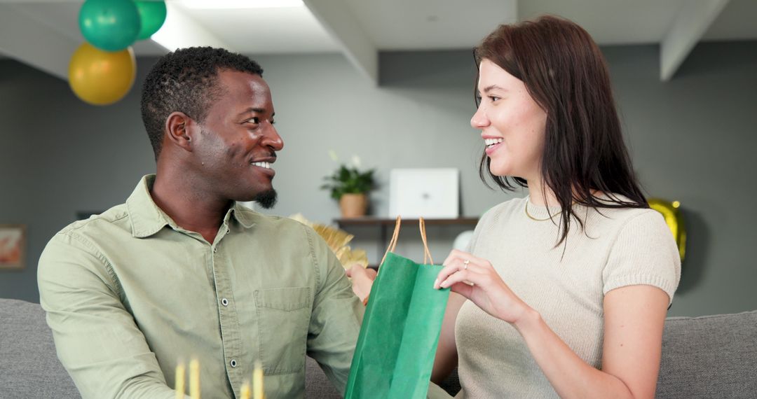 Happy Multiracial Couple Celebrating Birthday with Gift Exchange