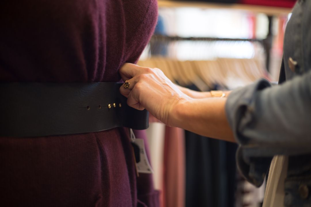 Close-Up of Hand Adjusting Belt on Mannequin Display