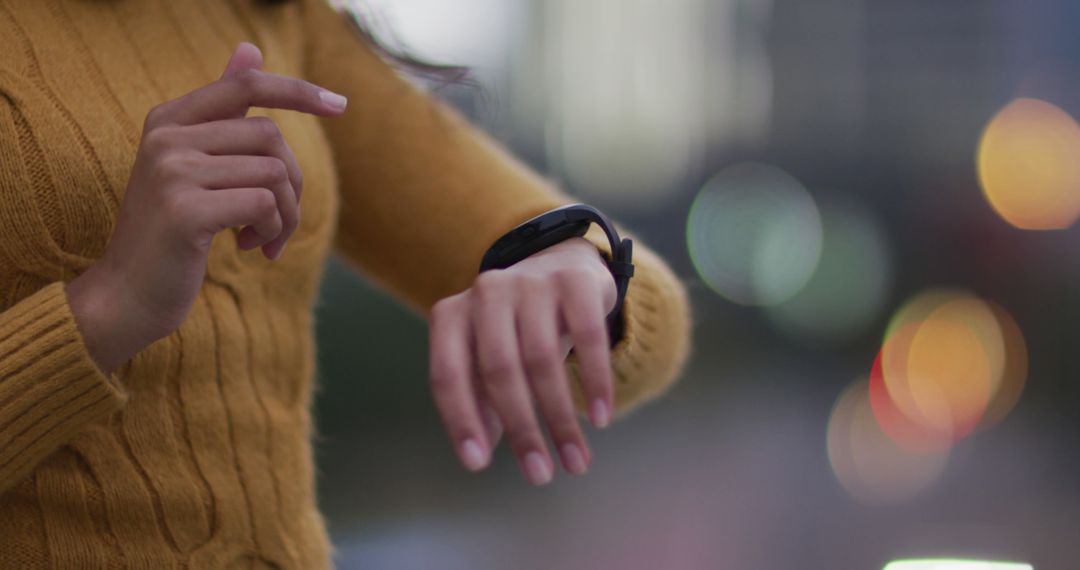 Person checking smartwatch in urban evening setting - Free Images, Stock Photos and Pictures on Pikwizard.com