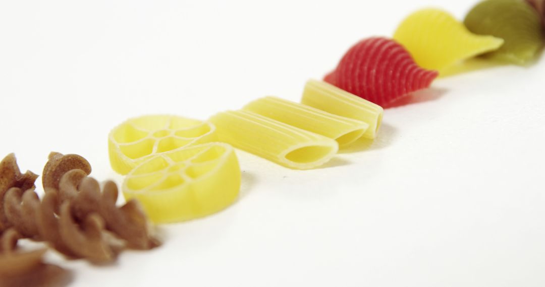 Assorted Colorful Uncooked Pasta on White Background - Free Images, Stock Photos and Pictures on Pikwizard.com