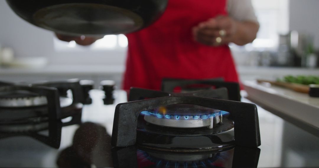 Person Cooking on Gas Stove in Modern Kitchen - Free Images, Stock Photos and Pictures on Pikwizard.com