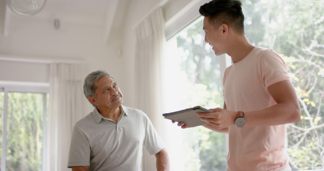 Senior Man Consulting with Physiotherapist Using Tablet