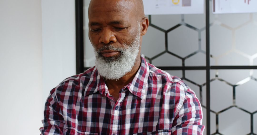 Thoughtful Mature Man With Gray Beard in Checkered Shirt - Free Images, Stock Photos and Pictures on Pikwizard.com