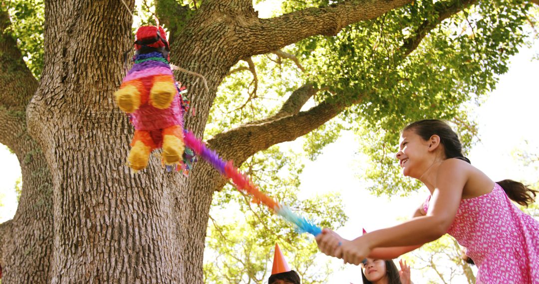 Celebration Fun: Young Woman Playing with Piñata Outdoors - Free Images, Stock Photos and Pictures on Pikwizard.com