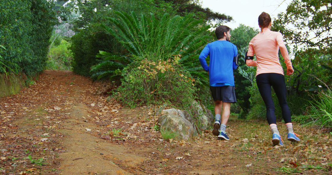 Couple Jogging on Forest Trail Surrounded by Greenery - Free Images, Stock Photos and Pictures on Pikwizard.com