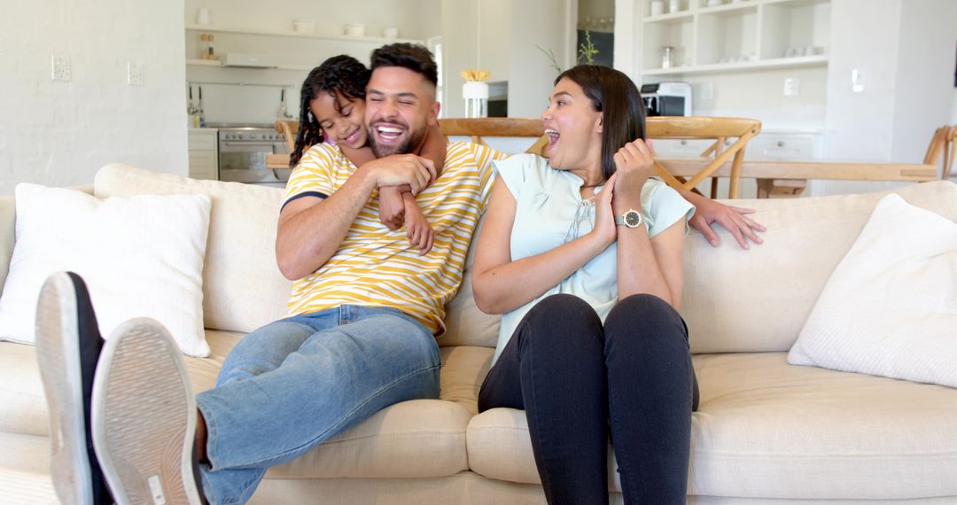 Diverse Family Sharing Laughter on Cozy Beige Sofa at Home