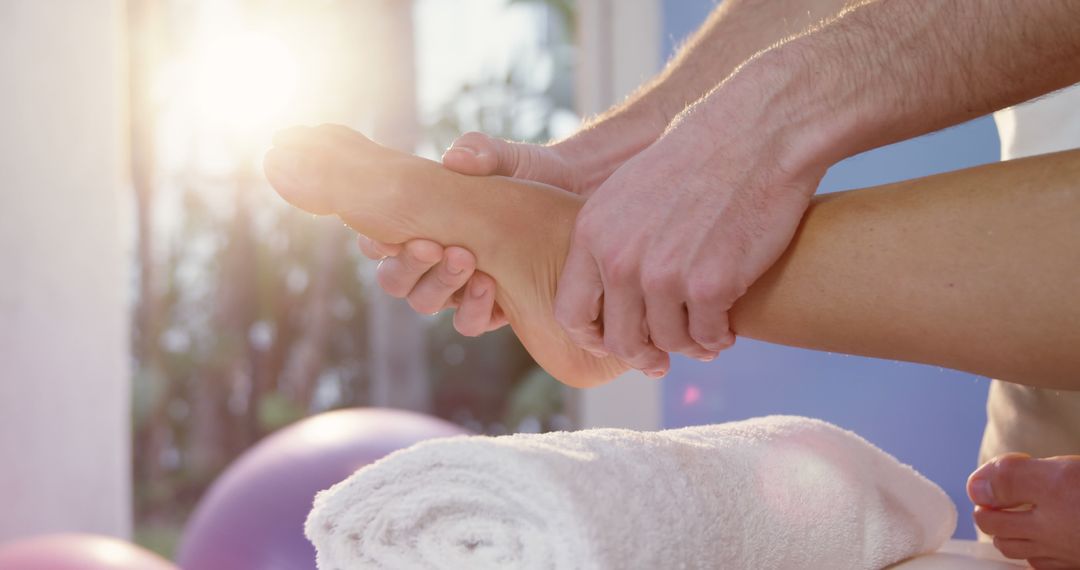 Close-Up of Therapist Giving Foot Massage in Sunny Wellness Setting - Free Images, Stock Photos and Pictures on Pikwizard.com