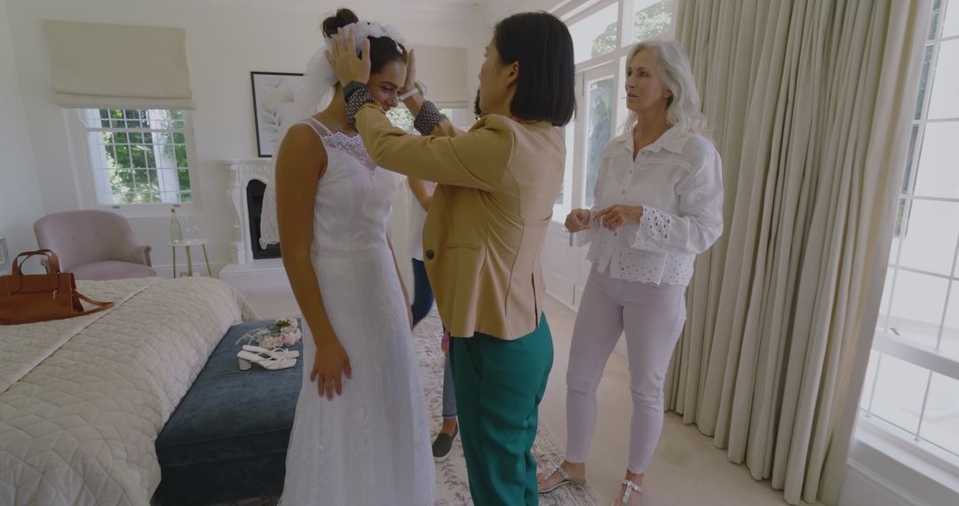 Bride Trying on Wedding Dress with Helpful Friends