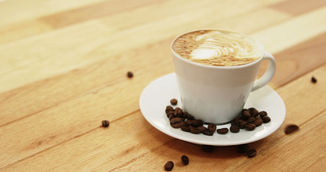 Latte Coffee in White Cup on Wooden Table with Coffee Beans - Free Images, Stock Photos and Pictures on Pikwizard.com