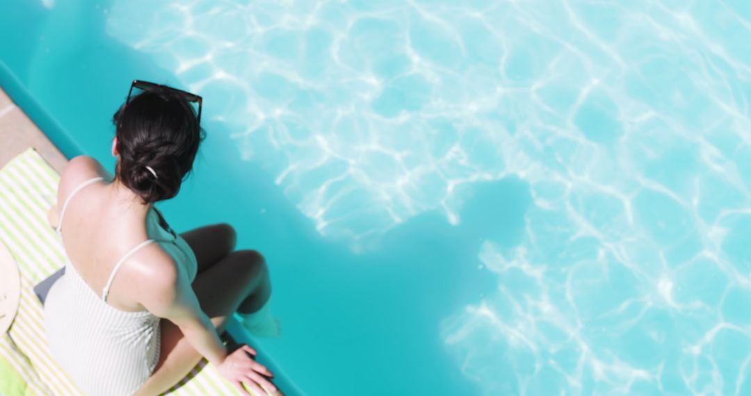 Woman Relaxing Poolside in Sunlight with Beach Hat