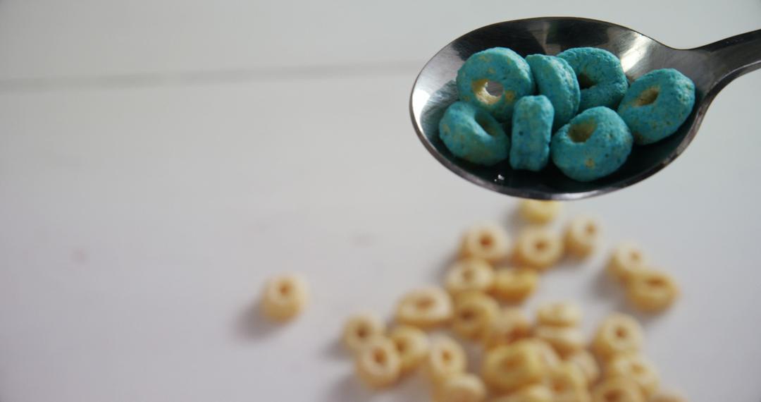 Closeup of Spoon with Blue Cereal Rings over Table - Free Images, Stock Photos and Pictures on Pikwizard.com