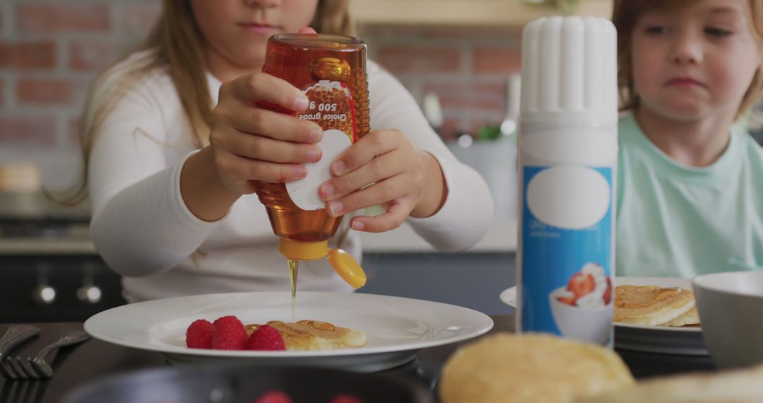 Children Pouring Syrup on Pancakes During Breakfast - Free Images, Stock Photos and Pictures on Pikwizard.com