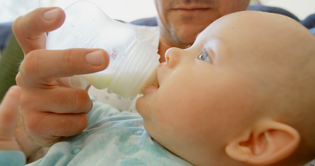 Close-up of Caregiver Bottle-Feeding Newborn in Nurturing Moment - Free Images, Stock Photos and Pictures on Pikwizard.com