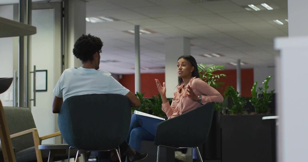 Coworkers in Deep Discussion in Modern Office Lounge
