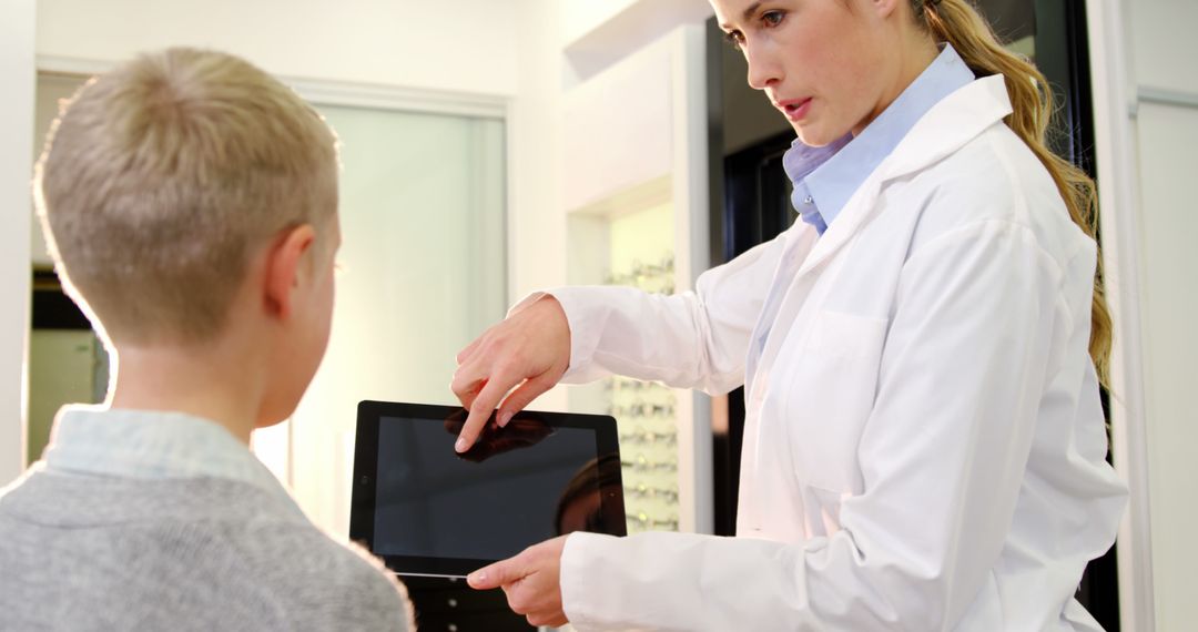 Female Optometrist Illustrating Eye Exam Results on Digital Tablet to Young Boy - Free Images, Stock Photos and Pictures on Pikwizard.com