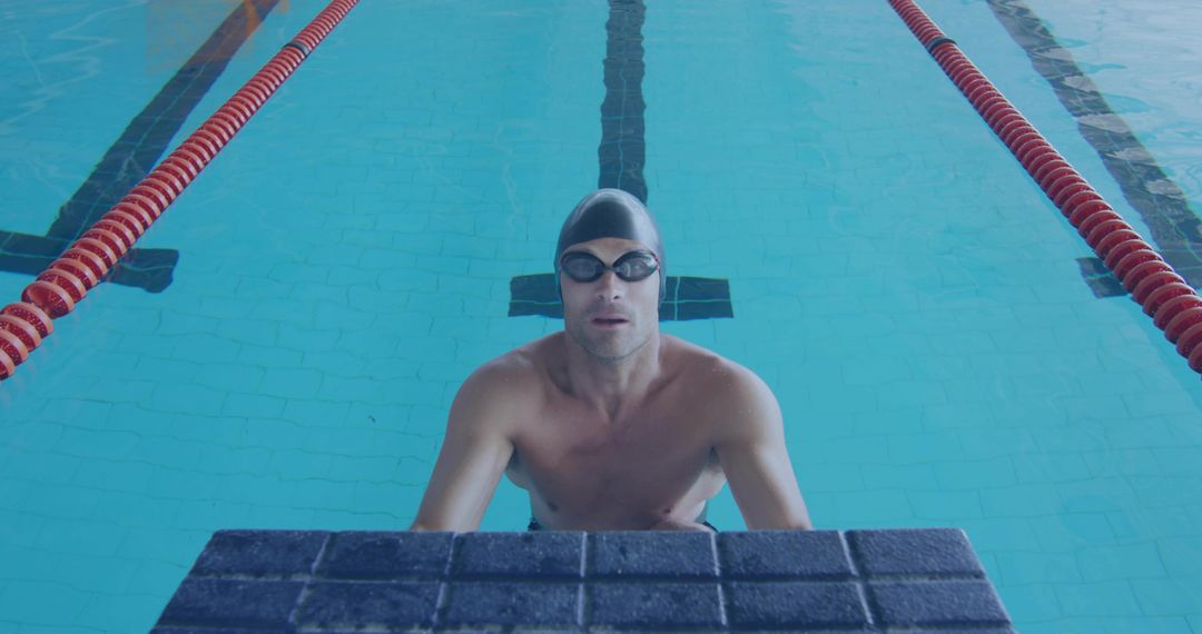 Competitive Swimmer Resting by Poolside with Swim Cap and Goggles