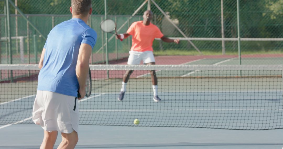 Two Men Playing Intense Doubles Tennis Match on Outdoor Court - Free Images, Stock Photos and Pictures on Pikwizard.com