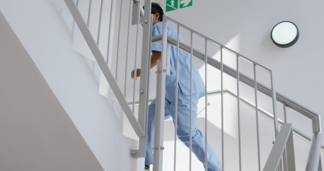 Healthcare Worker Climbing Stairs in Modern Hospital Environment - Free Images, Stock Photos and Pictures on Pikwizard.com