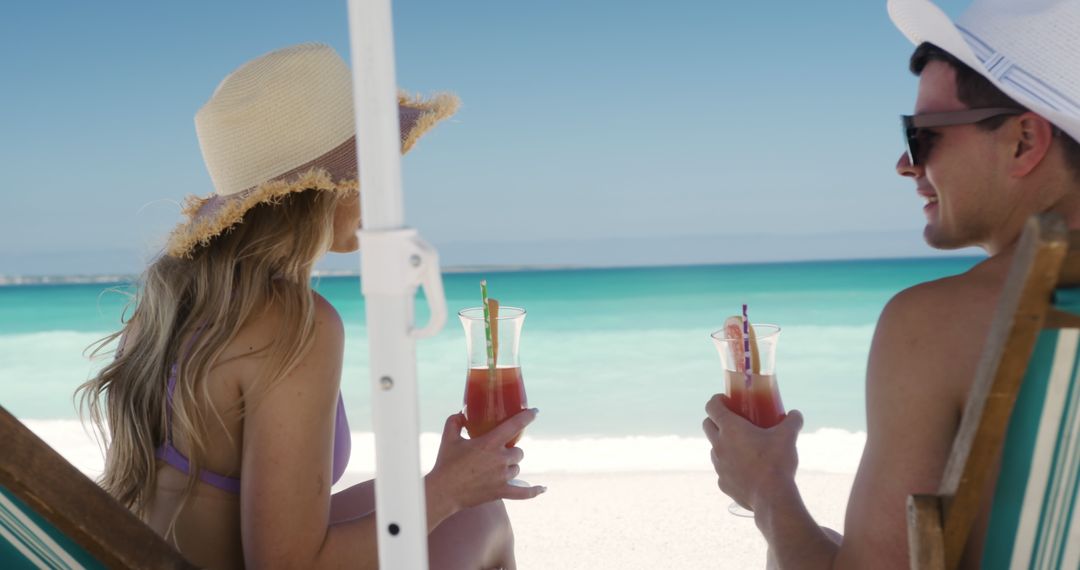 Couple Relaxing on Beach Chairs Holding Cocktails - Free Images, Stock Photos and Pictures on Pikwizard.com