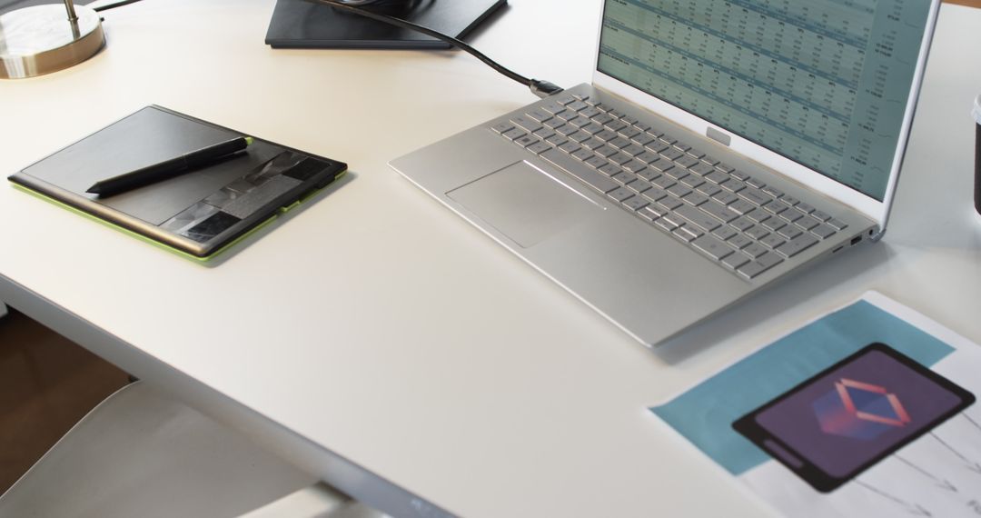 Creative Workspace with Laptop and App Design Draft