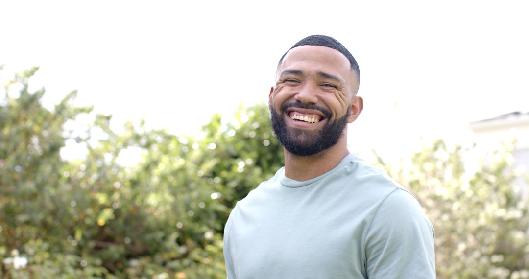 Smiling Man Enjoying Nature in Sunny Garden